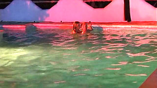 Two sexy lesbian chicks are swimming together in the swimming pool