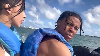 A black man fucks a juicy Cuban woman with fake big tits on jetski