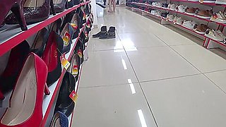 and foot fetish in a public place. Beautiful legs in stockings and a juicy ass under a short dress in a shoe store.